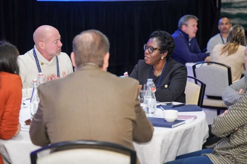 The Goddard School leadership and franchisees in discussion at a table during franchise convention.