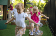 young girl joyfully plays on a wooden climbing structure