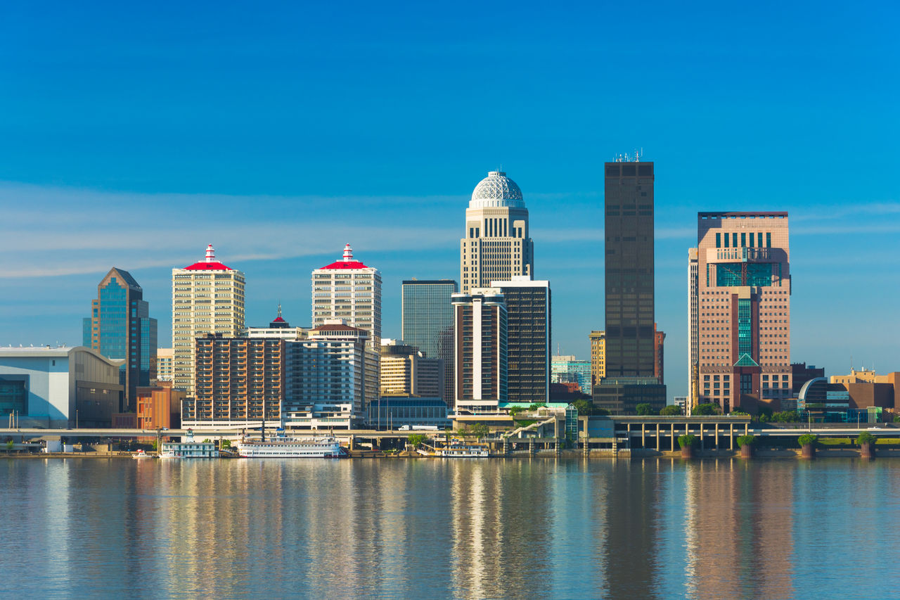 Image of the downtown Louisville skyline with reflections on the Ohio River.