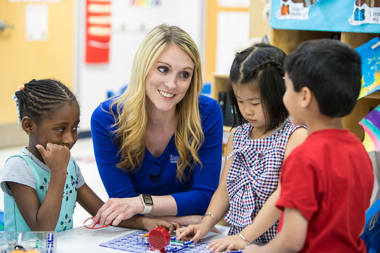 Teacher talking and smiling with three students